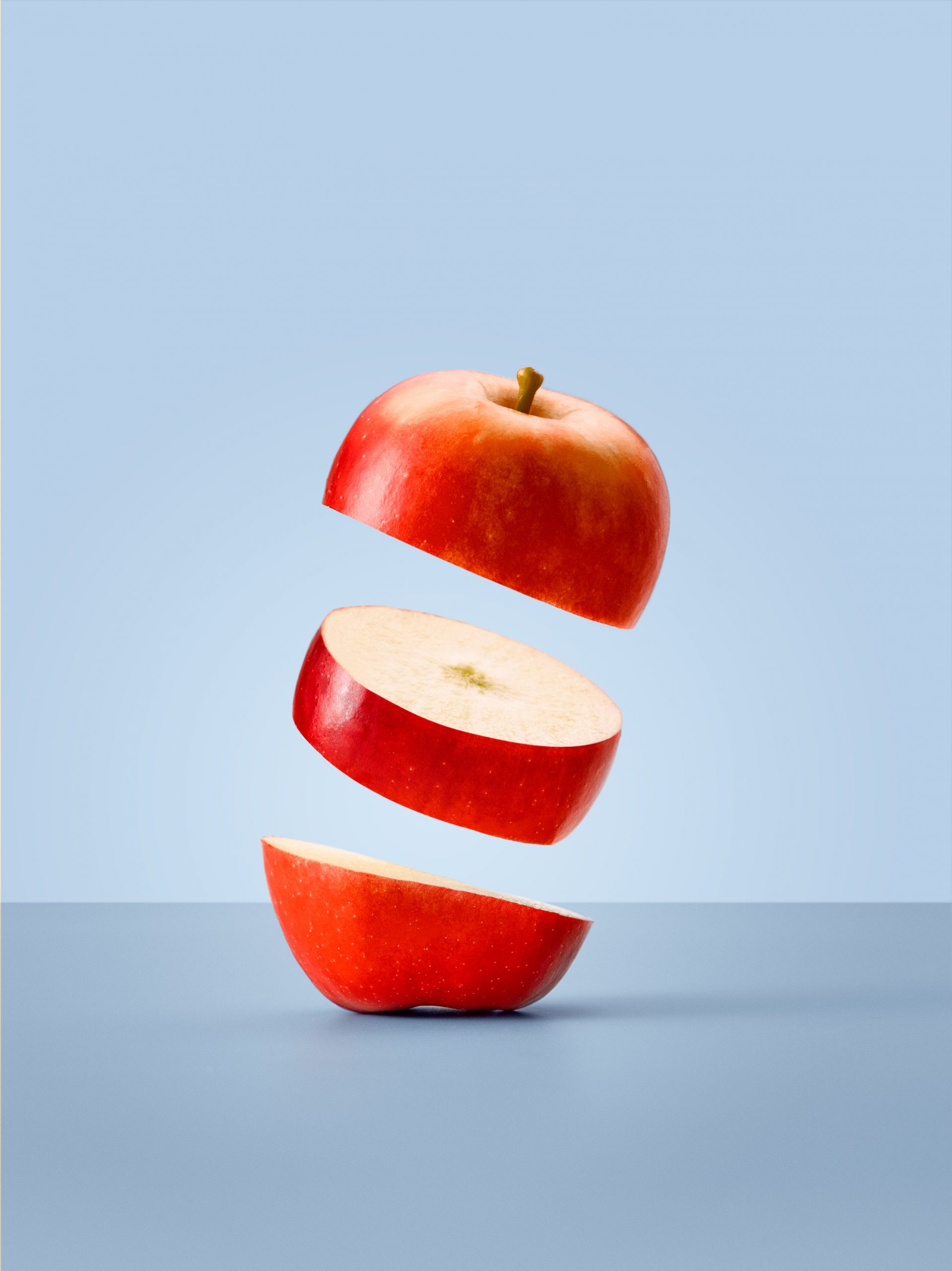 one rockit apple sliced into three parts floating slightly higher than the part below