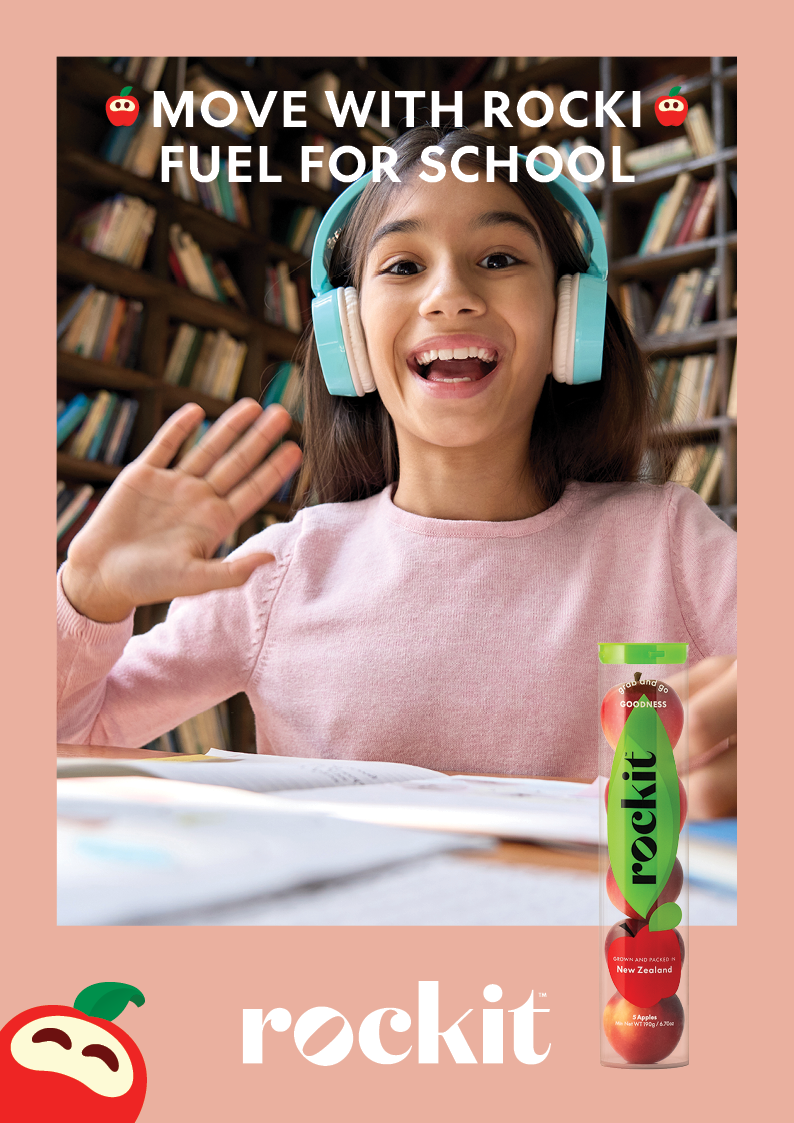 Young girl in a library with headphones on eating a Rockit apple