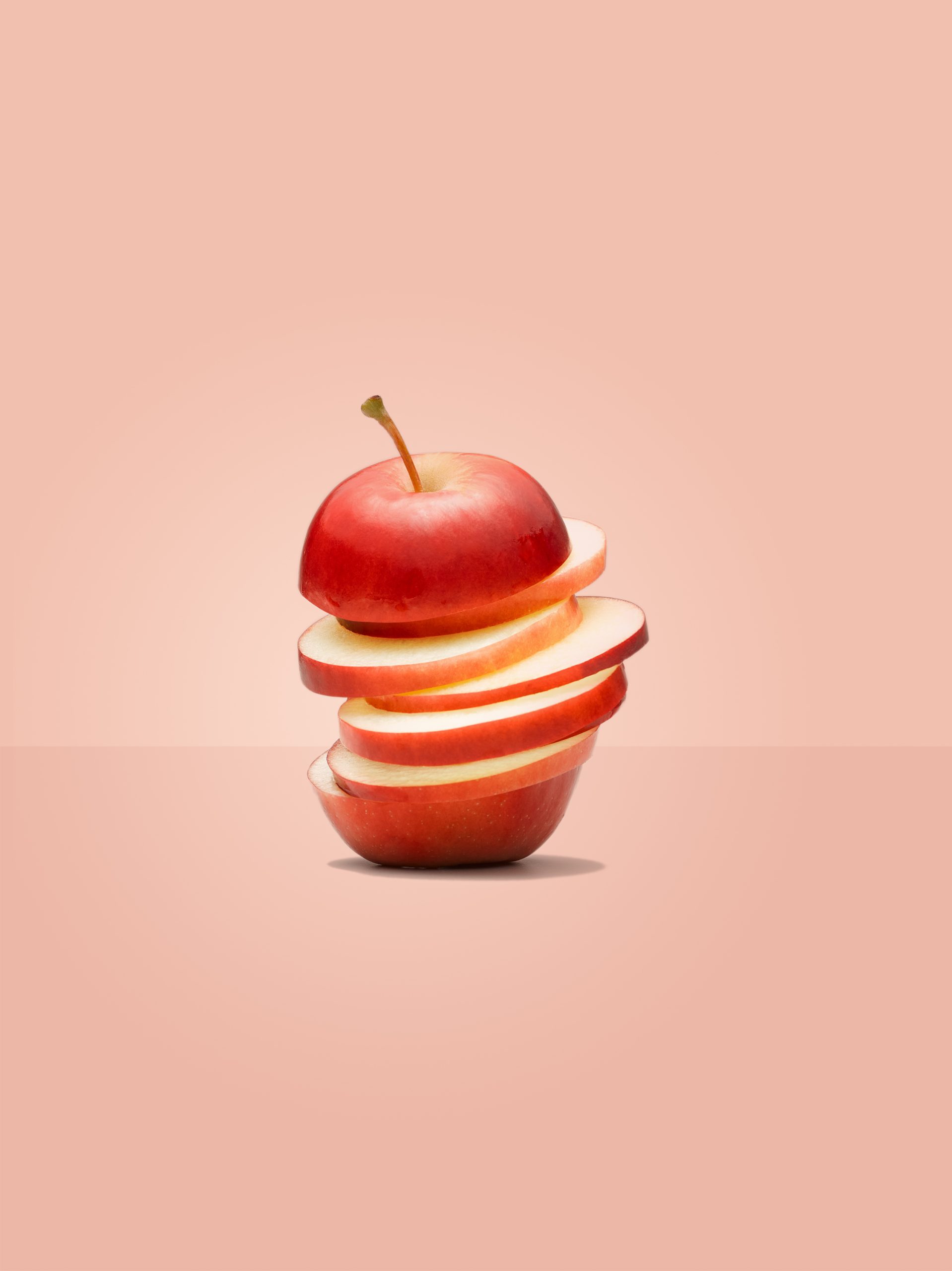 One Rockit apple sliced into multiple slices, stacked on top of each other.